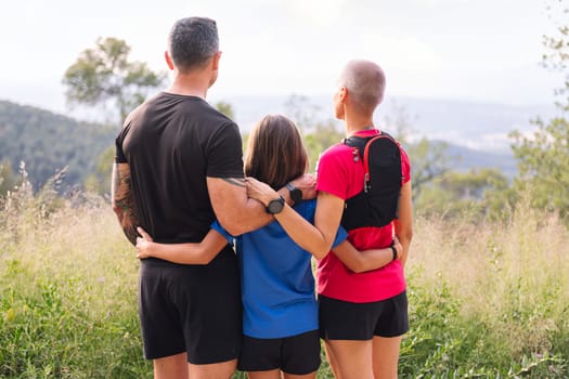 rear view of a family looking at the landscape after doing sports in the countryside, concept of active lifestyle and sport with kids in the nature