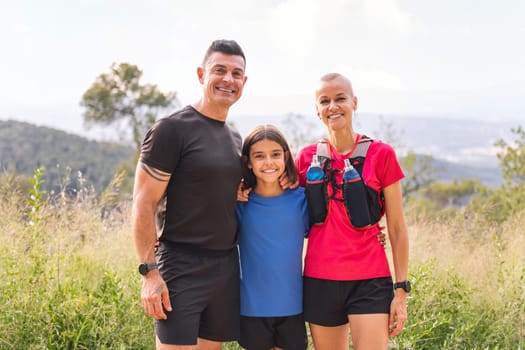 portrait of a happy family looking at camera after doing sports in the countryside, concept of active lifestyle and sport with kids in the nature