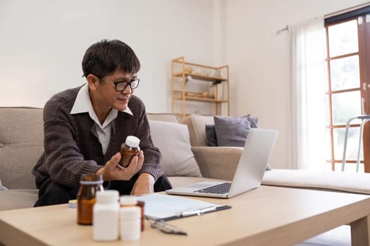 Asian Mature adult man having video call consulting with doctor medicine on laptop from home, telehealth or telemedicine concept.