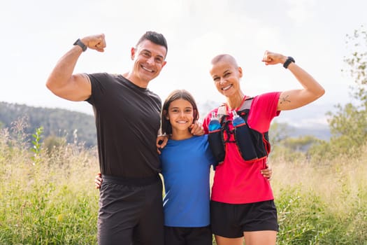 portrait of a sports family smiling happy looking at camera after doing sport in the countryside, concept of active lifestyle and sport with kids in the nature, copy space for text