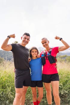 vertical photo of a sports family smiling happy looking at camera after doing sport in the countryside, concept of active lifestyle and sport with kids in the nature, copy space for text