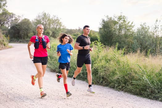 family practicing trail running in the countryside, concept of sport in nature with kids and healthy lifestyle
