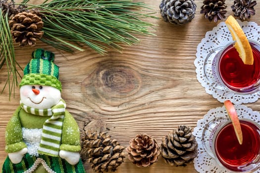 Hot mulled wine with spices on wooden background. Christmas tree branches, gifts and cones. Flat lay, copy space, top view. Holidays.