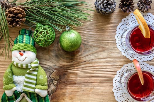 Hot mulled wine with spices on wooden background. Christmas tree branches, gifts and cones. Flat lay, copy space, top view. Holidays.