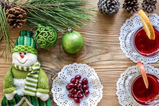 Hot mulled wine with spices on wooden background. Christmas tree branches, gifts and cones. Flat lay, copy space, top view. Holidays.