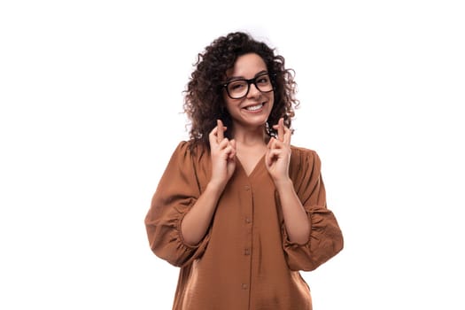young cute caucasian curly brunette woman dressed in a beautiful brown shirt.