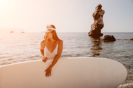 Close up shot of happy young caucasian woman looking at camera and smiling. Cute woman portrait in bikini posing on a volcanic rock high above the sea