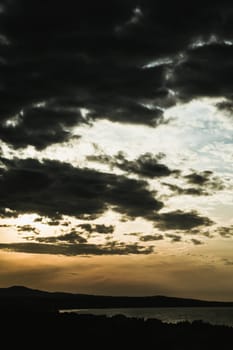 Abstract background sky Dawn Sunset Contrast dark shadow bright cloud sun orange silhouette above the mountains near the sea.