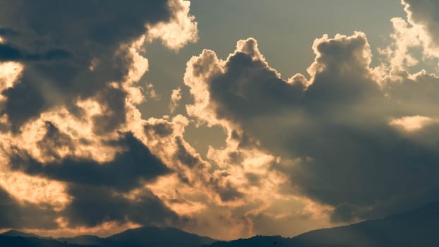 Beautiful dramatic sky with clouds at sunset or sunrise. Sunset sky at dusk in the evening with natural sky background with golden orange clouds.