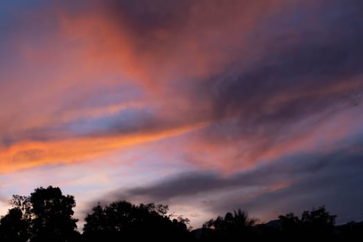 Aerial view of the beautiful sunset or sunrise scenery on the top of the mountain. Beautiful tropical valley silhouettes with the last rays of the sun. Dramatic sundown landscape.