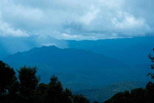 Aerial view over the mountains with sea of fog during morning sunrise in blue sky. Sea of clouds around mountain peaks at sunrise. Unseen travel in Northern Thailand