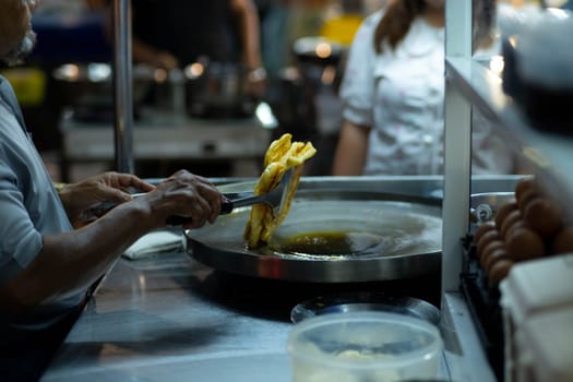 Roti Making, roti thresh flour by roti maker with oil. Thai Pancake topped with sweetened condensed milk and then sprinkle with sugar. Thai Street Food and Desserts.