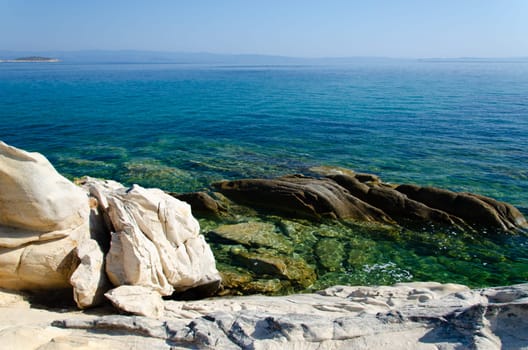 White stone shore and azure sea. Karidi Beach, Halkidiki. You can see the rocky bottom in the clear water.