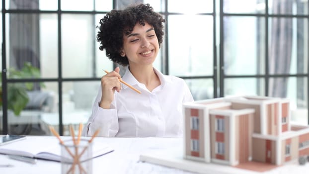 female architect designer examines house layout in office