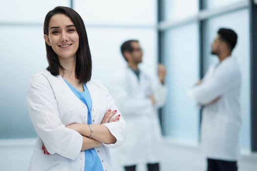 Confident female doctor posing in her office and smiling at camera, health care and prevention concept