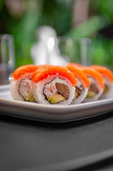 Sushi roll with salmon, shrimp, avocado and cream cheese on a plate close-up. High quality photo