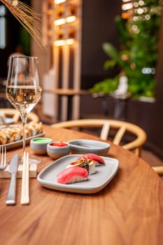 Nigiri set: tuna, eel and tuna tataki on a plate on a table in a sushi bar on a plate close-up. High quality photo