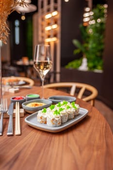 Sushi roll with cream cheese, sesame seeds and green flying fish caviar on a plate close-up. High quality photo