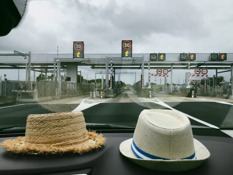 The hats of two travelers near the windshield in front of the Toll gate