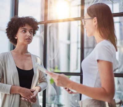 Two middle age beautiful businesswomen smiling happy and confident working together. Shaking hands with smile on face for agreement at the office