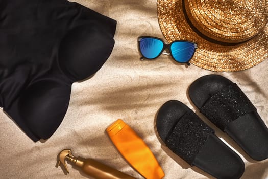 Summer background with straw hat, sunglasses, sunscreen bottle and flip flops. Top view. Still life. Copy space. flat lay