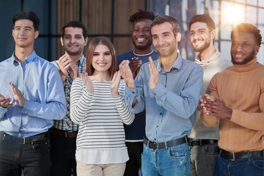 Human resources. Group portrait of smiling employees of a friendly team of different racial genders standing together in an office.