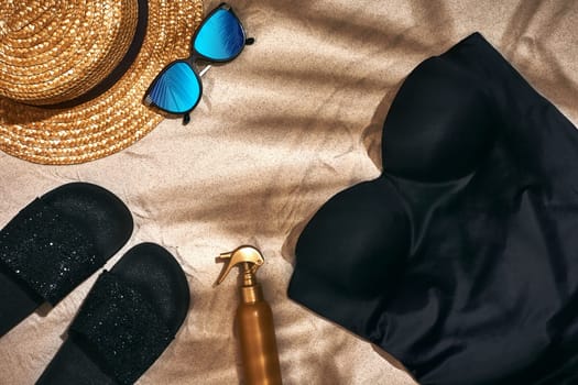 Summer background with straw hat, sunglasses, sunscreen bottle and flip flops. Top view. Still life. Copy space. flat lay