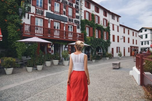 A woman near house with hanging peppers at Espelette, France