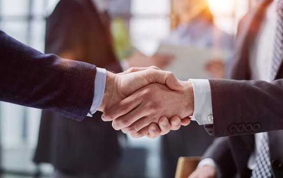 composite of Business people shaking hands against blurred background