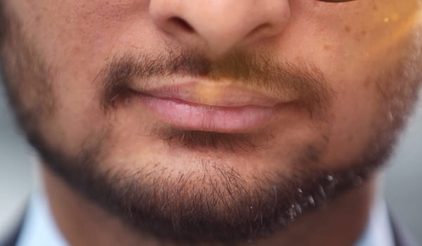 Close up cropped half face photo of stylish young man's bristle with thoughtful, minded expression