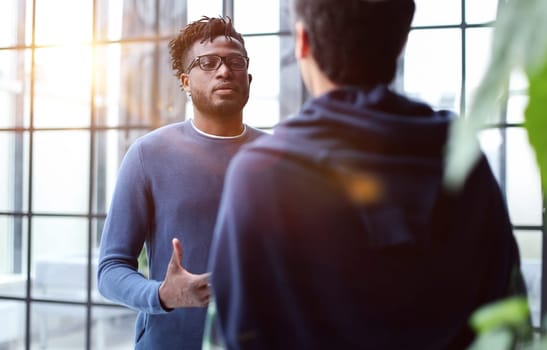 Business people talking near glass wall in office