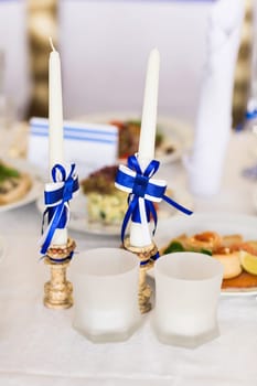white wedding candles with bright blue ribbons