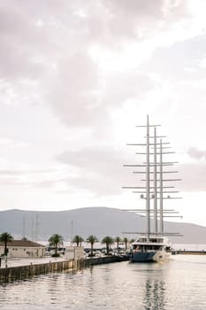 Large yacht with lowered sails is moored at the seashore. High quality photo
