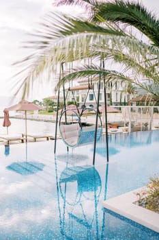 Hanging chair on stands in the pool of a hotel complex. High quality photo