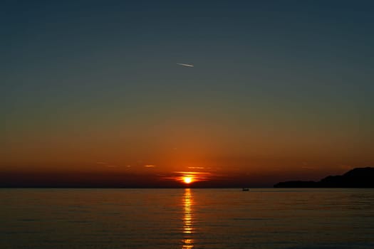 Orange sunset over the sea and mountains. High quality photo