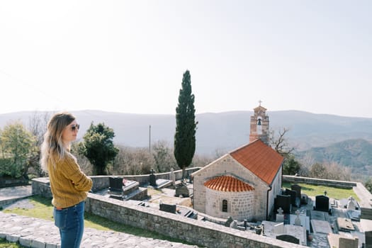 Young woman stands on an observation deck near the Church of St. Nicholas. Baosici, Montenegro. High quality photo