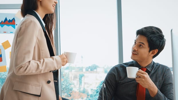 Two business people talk project strategy at office meeting room. Businessman discuss project planning with colleague at modern workplace while having conversation and advice on financial report. Jivy