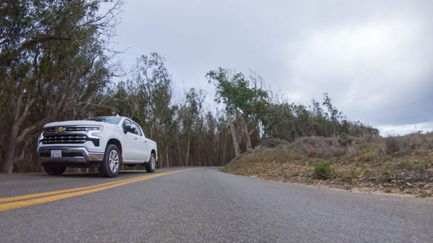 Santa Maria, California, USA-December 6, 2022-In this serene winter scene, a vehicle carefully makes its way along Los Osos Valley Road and Pecho Valley Road within Montana de Oro State Park.