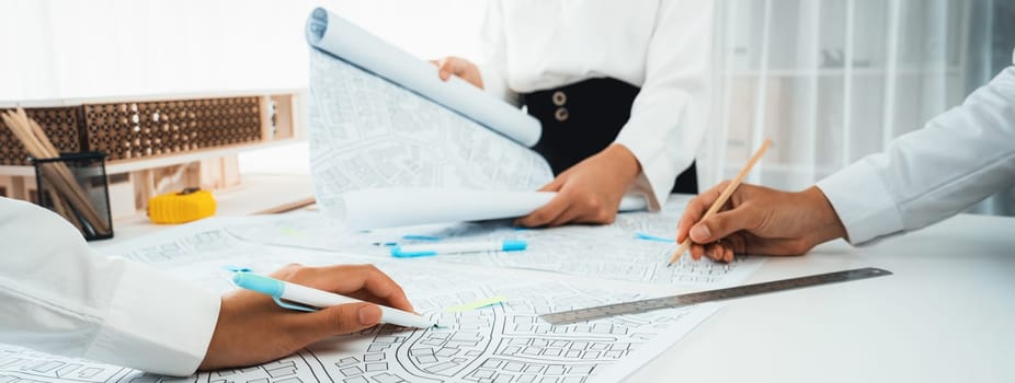 Worker, architect and engineer work on real estate construction project oratory planning with cartography and cadastral map of urban town area to guide to construction developer business plan of city