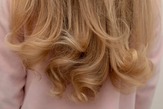 The girl is standing back with beautiful curly hair