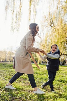 Single mother spending some time at the park with her little son at autumn