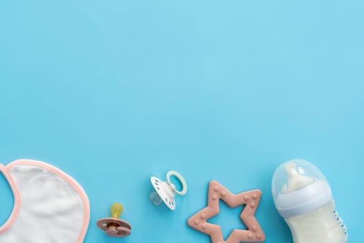 A collection of baby accessories neatly presented on a soothing blue background, captured from a