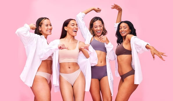 Fun, dancing and women friends in underwear in studio on pink background for beauty or skincare. Lingerie, health and wellness of female model group move for diversity, body positive or inclusion.
