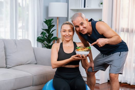 Healthy senior couple in sportswear with a bowl of fruit and vegetable. Healthy cuisine nutrition and vegan lifestyle for fitness body physique concept. Clout