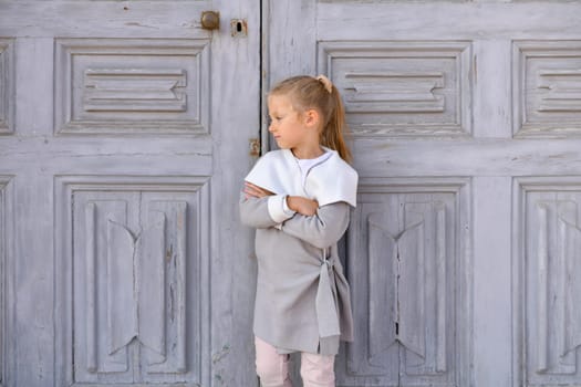 Girl near a grey vintage door
