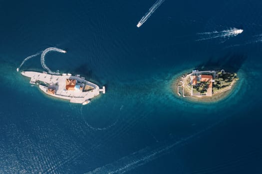 Boats sail around the islands of Gospa od Skrpjela and St. George. Montenegro. Drone. High quality photo