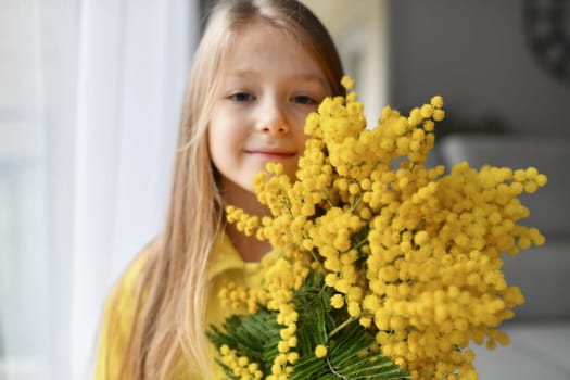 A girl smelling mimosa at spring