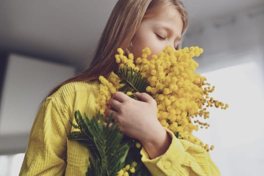 A girl smelling mimosa at spring