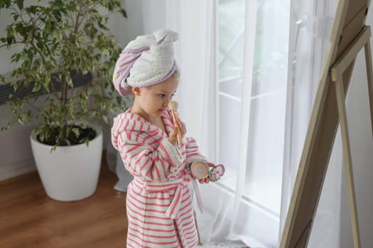 Little girl with a towel on her head doing makeup