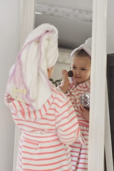 Little girl with a towel on her head doing makeup